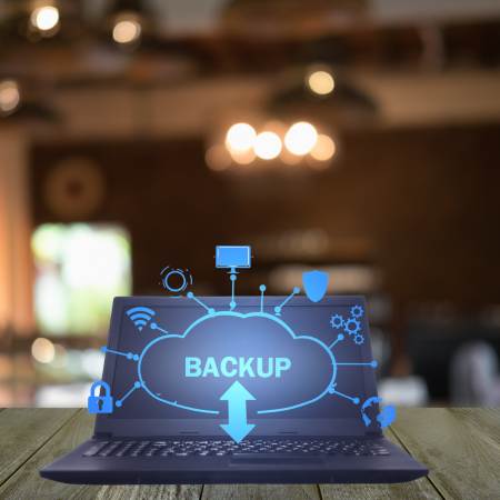 Computer su tavolo riportante la scritta Backup come rappresentazione grafica del creare backup per sito web