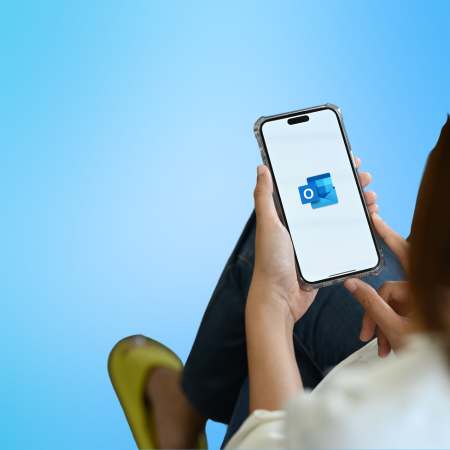 Immagine decorativa, con sfondo azzurro, con persona con smartphone che crea una propria firma su Outlook